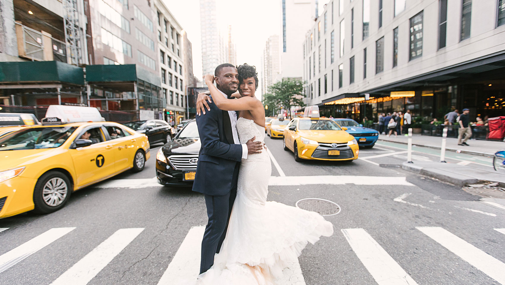 Daniel and Ahkilah embracing each other on a busy crosswalk in front of Kimpton Hotel Eventi