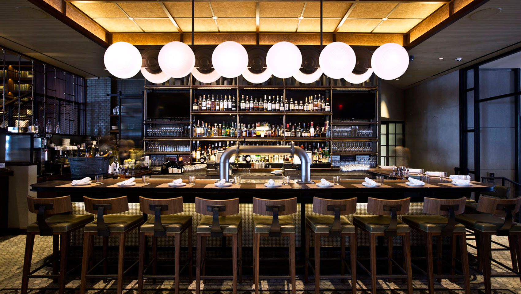 Back Bar bar seating underneath circular light fixture