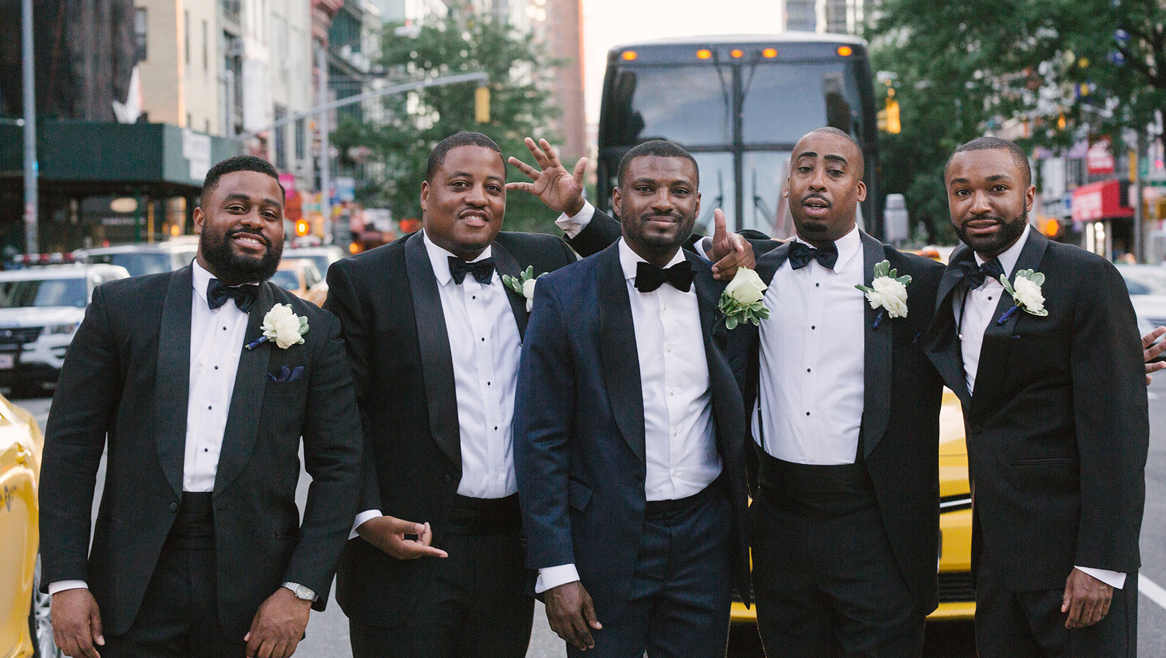 Daniel with his groomsmen in tuxedos on street crosswalk