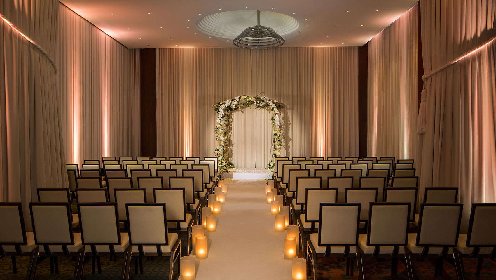 Ventana I wedding set up with chairs facing altar in room with curtains and high ceilings 