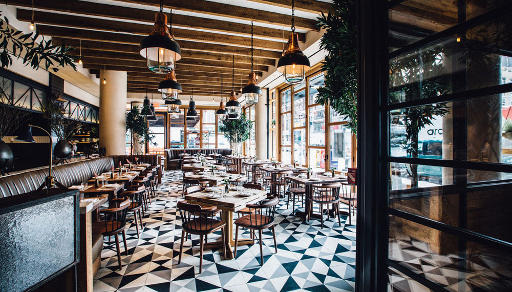 L'Amico restaurant dining area with tiled floors, wood paneled ceilings and wooden tables and chairs