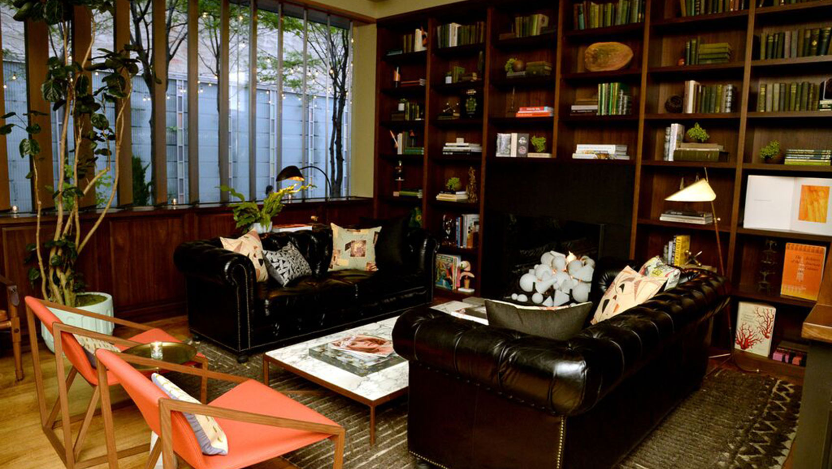 The Vine lounge seating with leather couches, marble coffee table, and shelves with books and accent pieces