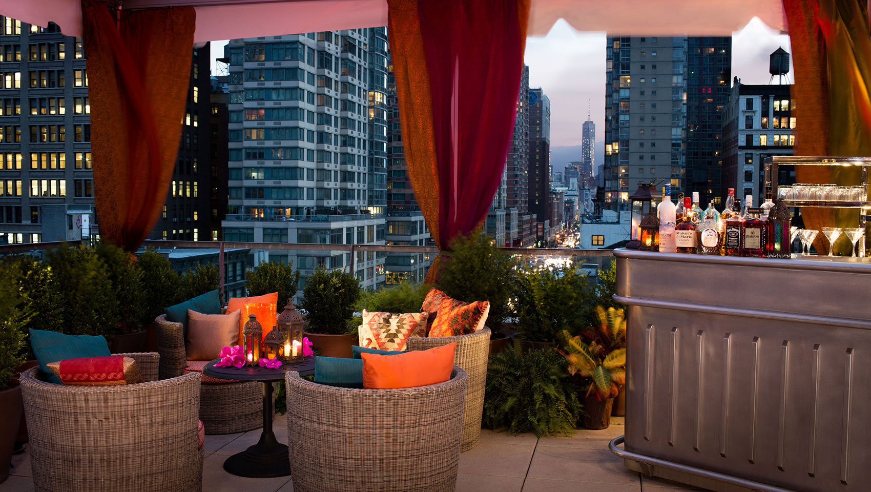 Kimpton Hotel Eventi outdoor event area with seating and bar overlooking street with surrounding skyscrapers