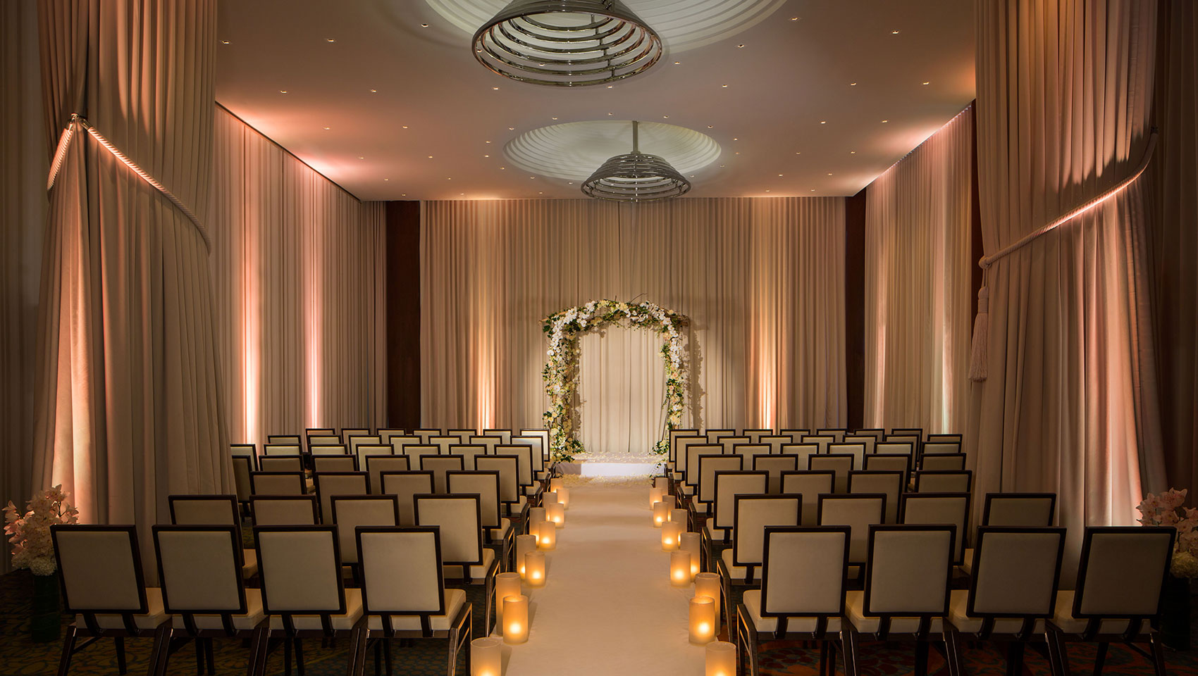 Ventana I wedding set up with chairs facing altar in room with curtains and high ceilings