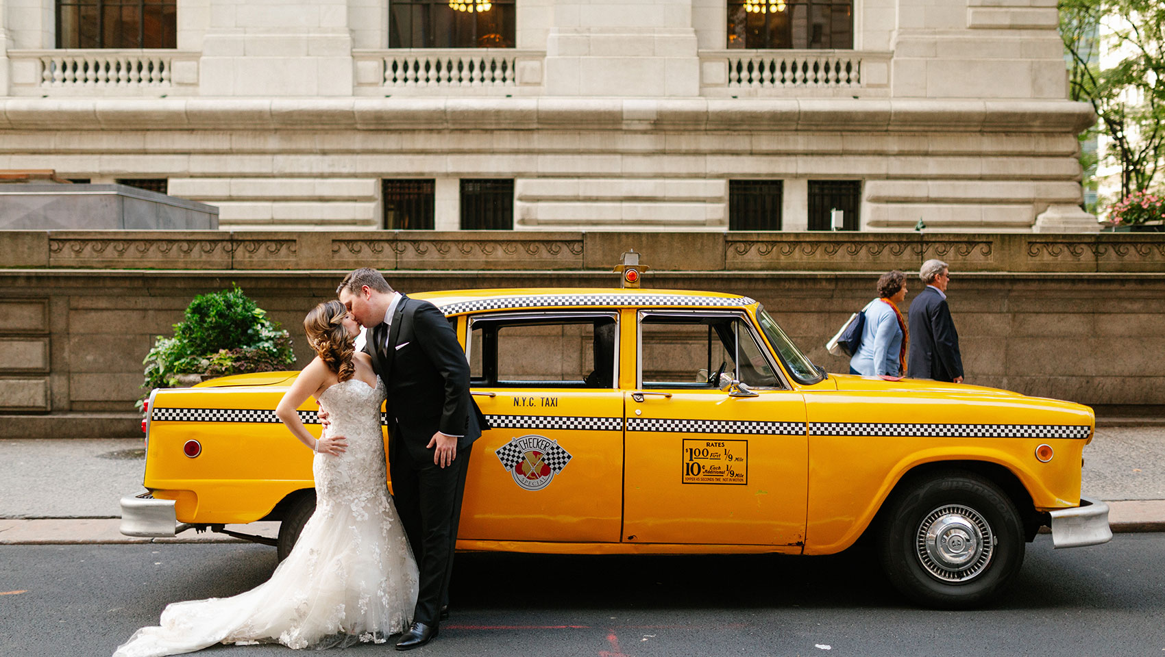 April and Daniel kissing in front of a New York city vintage taxi cab