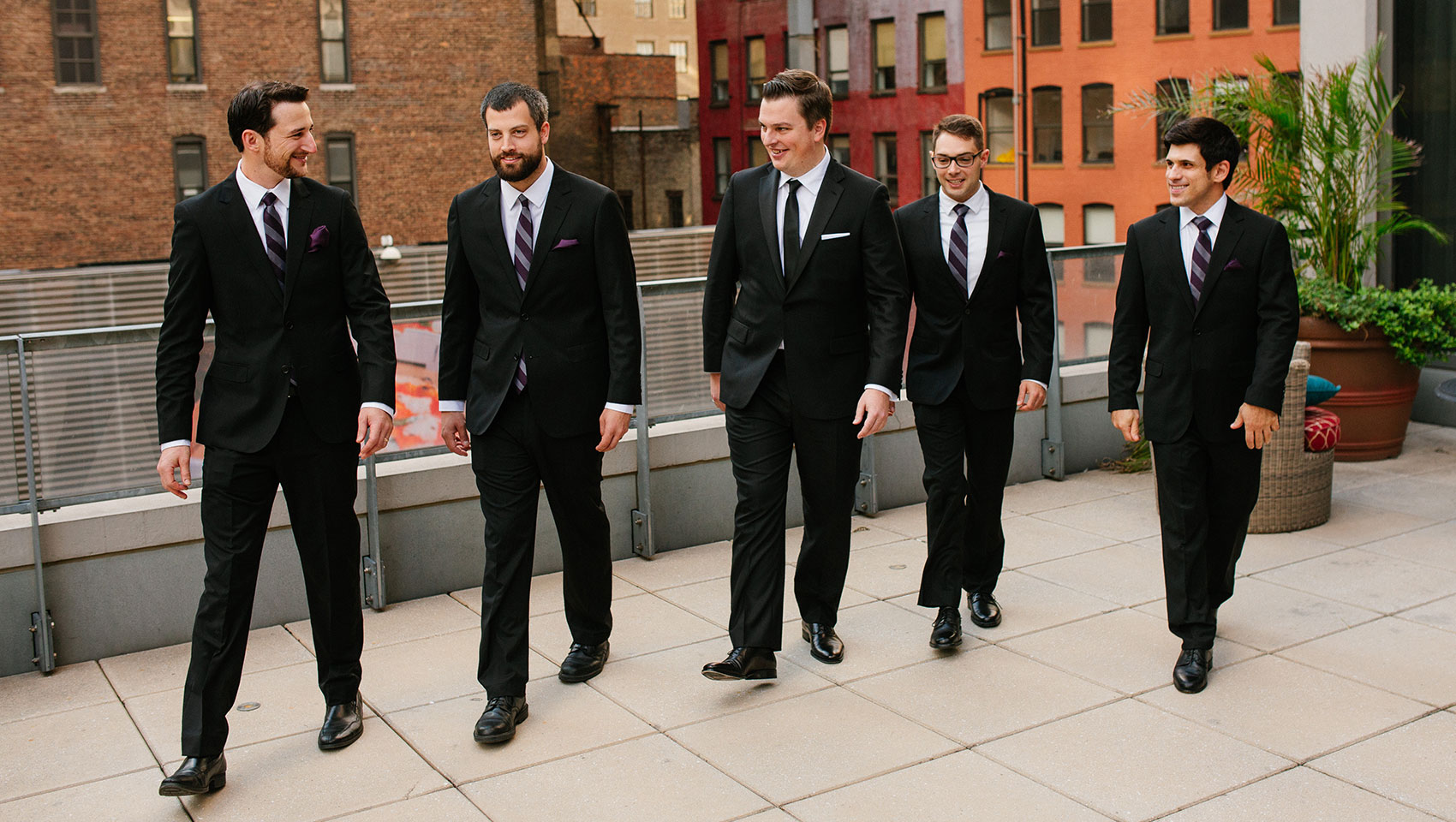 Daniel with his groomsmen as they are all in wedding attire on a terrace