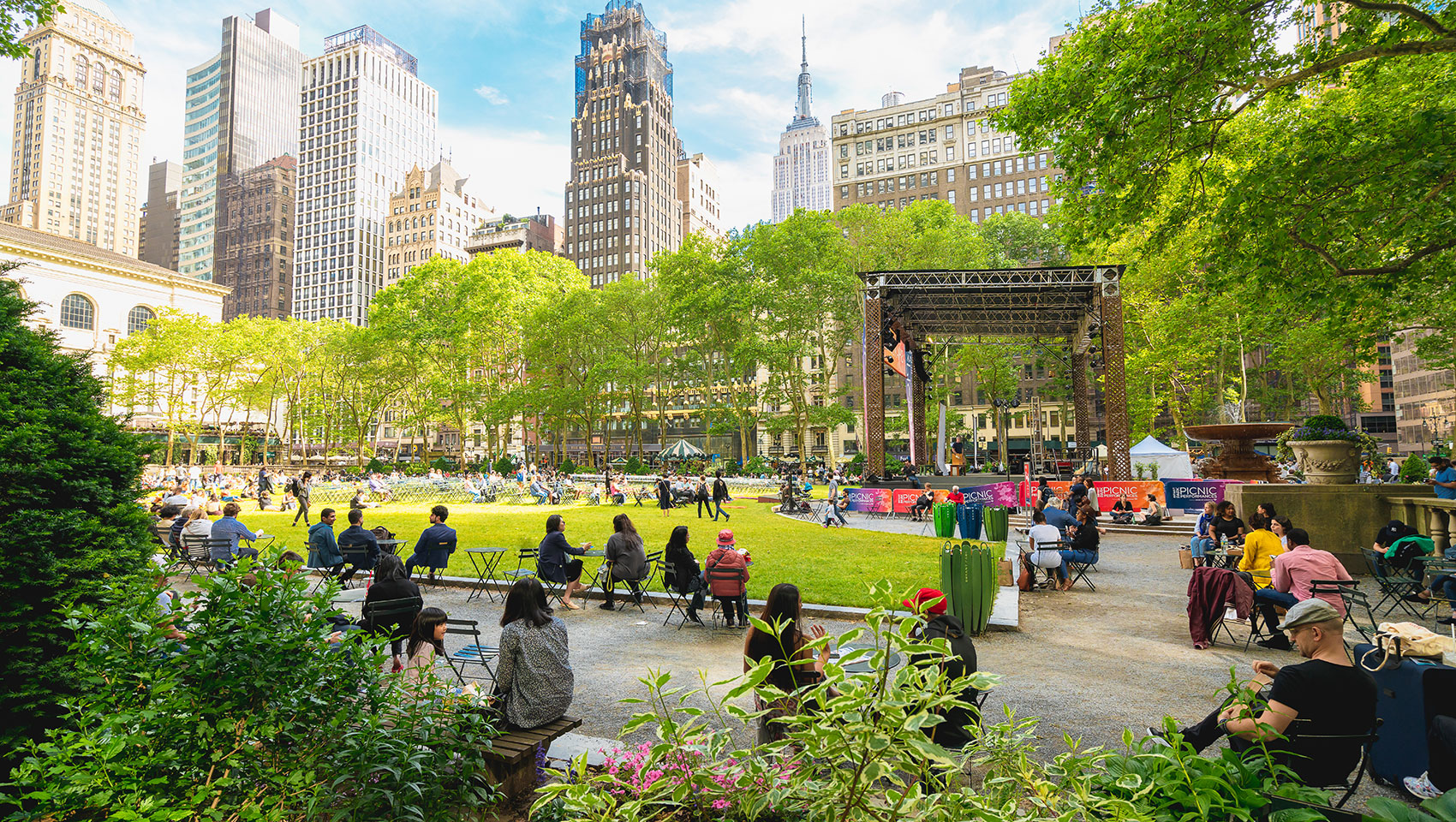 Bryant Park in Summer with green grass, trees, and people enjoying the park