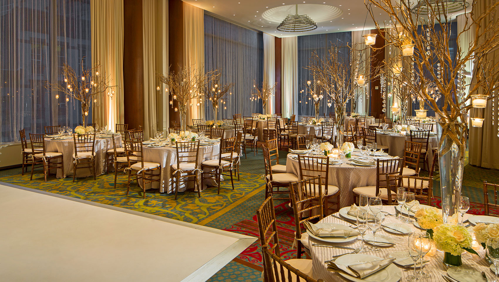 Ventana I and II with circular tables and branched center pieces with hanging candles and crystals