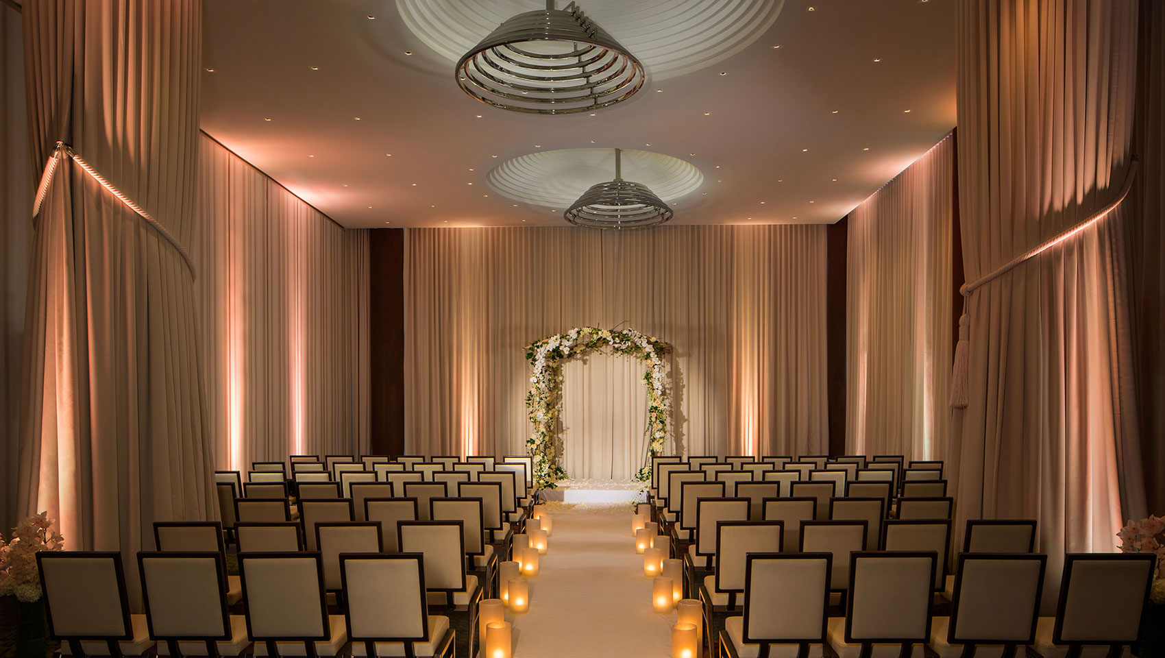 Ventana I wedding set up with chairs facing altar in room with curtains and high ceilings