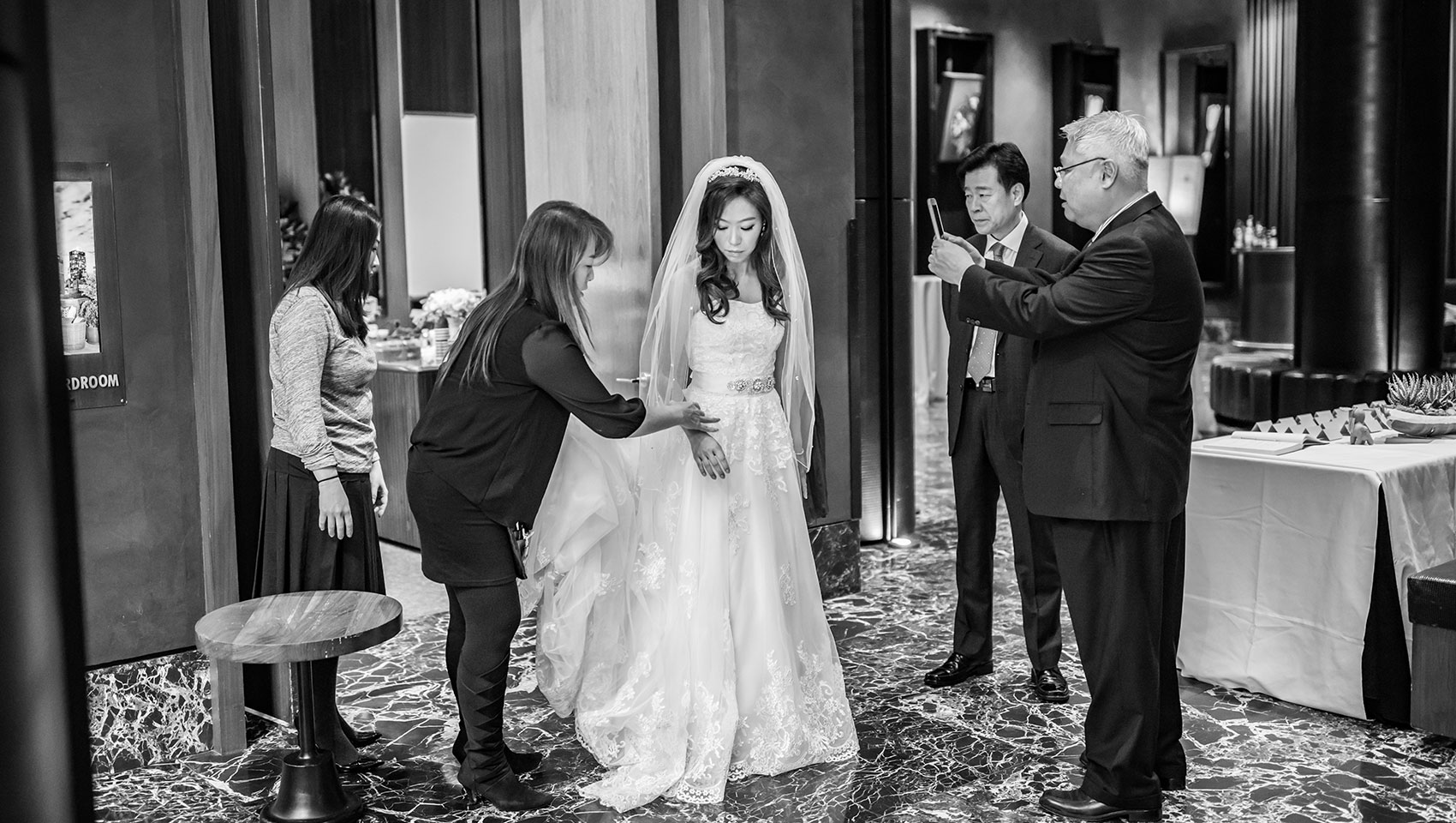 Eun Joon with family on wedding day as someone takes pictures on a phone