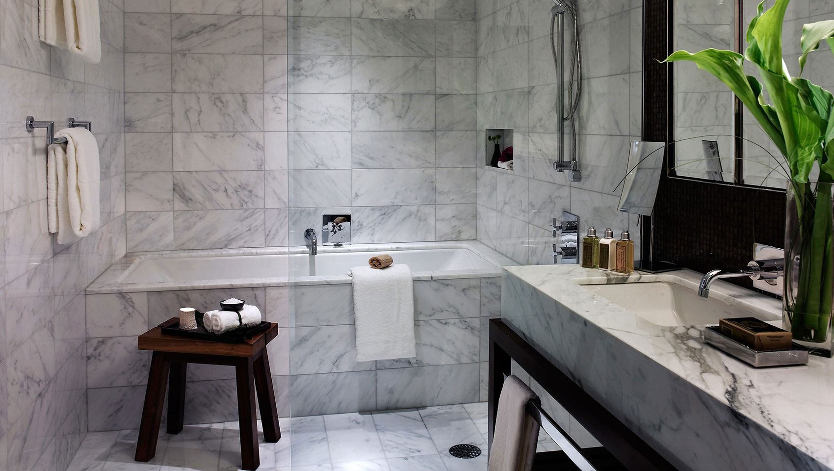 One bedroom premiere bathroom with marble finish bathtub and marble countertop