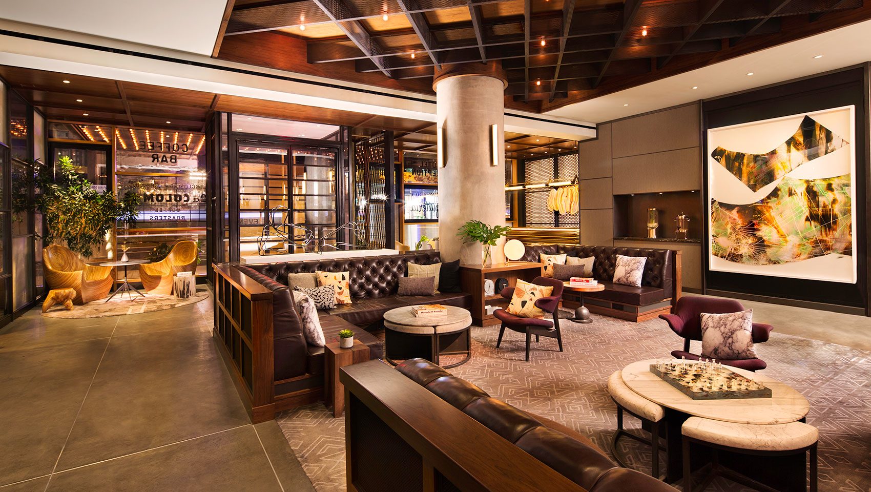 Kimpton Hotel Eventi lobby seating with leather seating, coffee tables, and large hanging art pieces