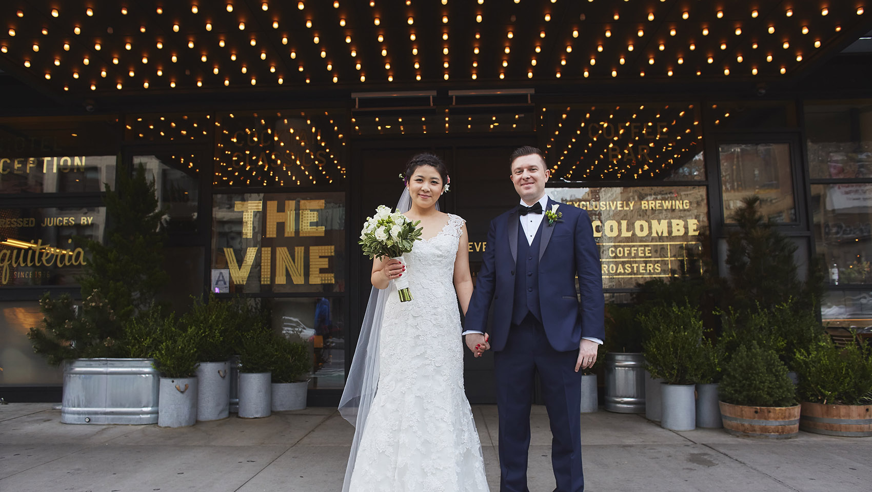 Yoko and Roman standing in front of the Hotel Eventi front entrance façade