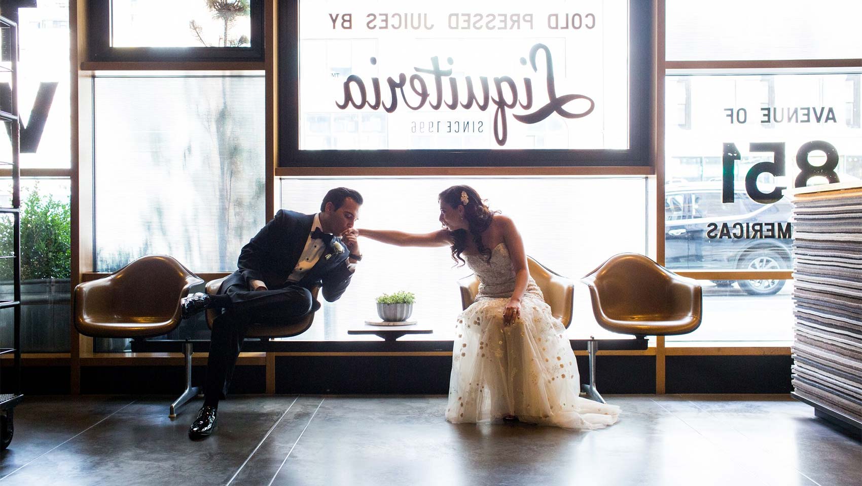 Ravi kissing Natalie's hand in Hotel Eventi front lobby seating