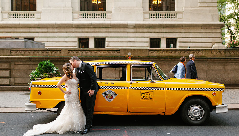 April and Daniel kissing in front of a New York city vintage taxi cab
