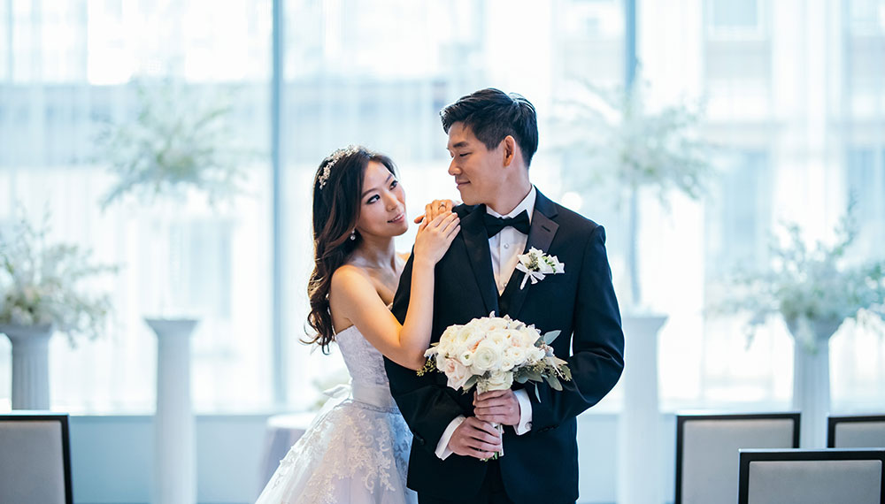 Bridge and groom looking at each other longingly while groom holds bouquet