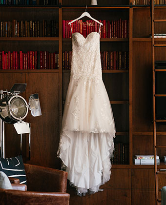 Wedding dress being hung from bookcase