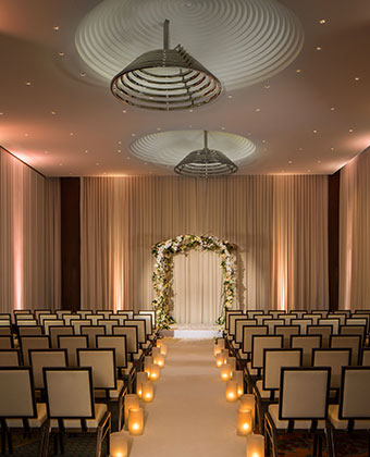 Ventana I wedding set up with chairs facing altar in room with curtains and high ceilings