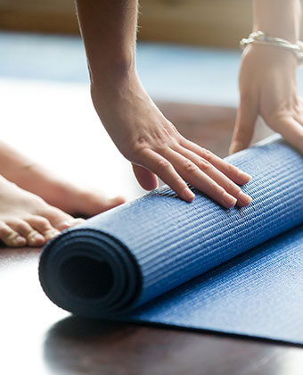 Woman unrolling yoga mat